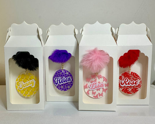 Personalised boxed keychain gift with fluffy pom pom and background.